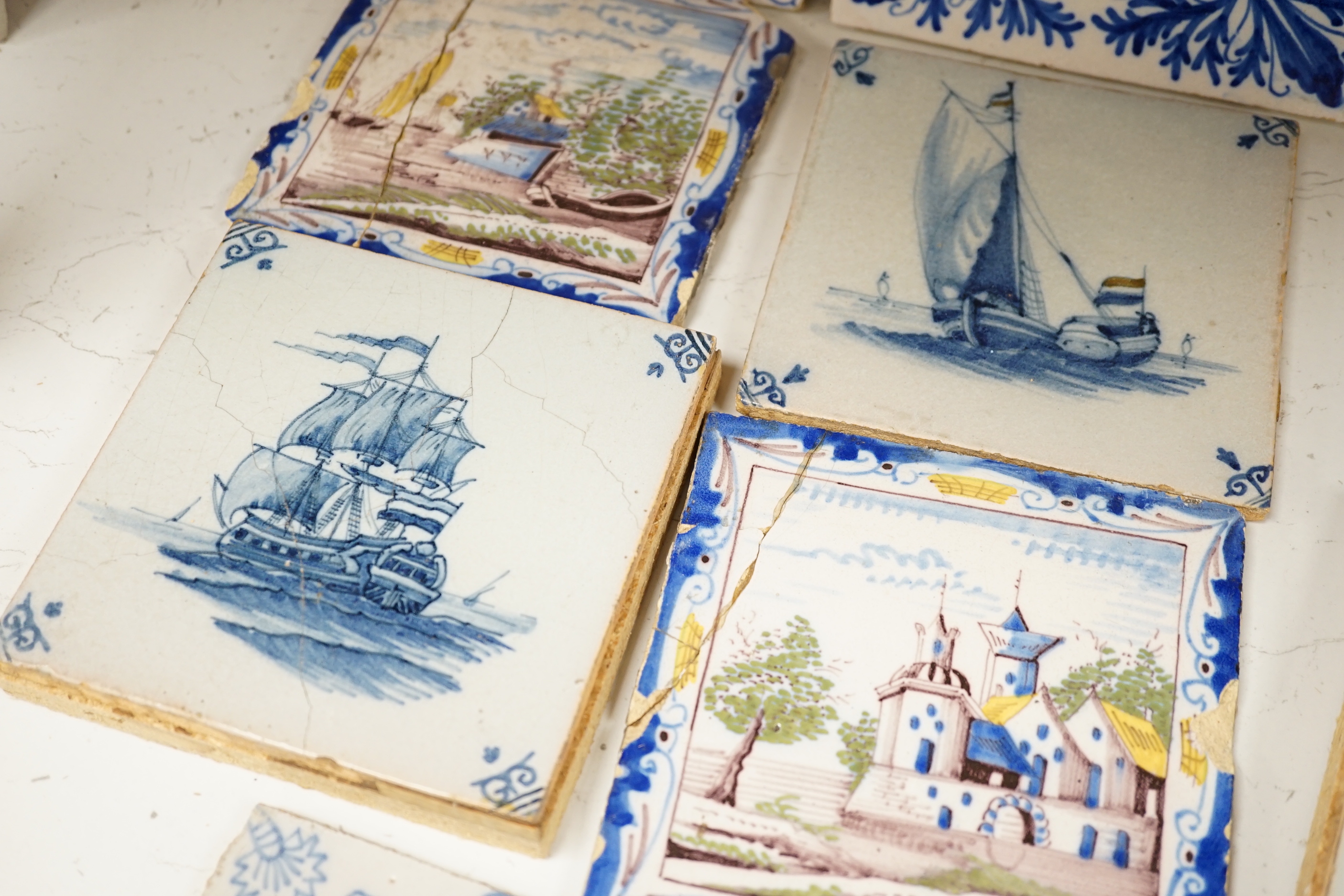 A group of Delft tiles including two polychrome examples and three decorated with ships, 18th/19th century, approximately 12.5cm x 12.5cm (a.f.)